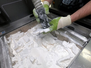 Mane taking out models from white polyamide powder in working chamber of 3D printer, cleaning and...