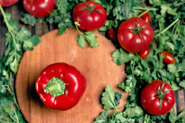 red pepper and fresh tomatoes on a wooden background.