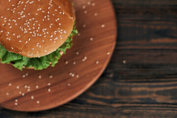 delicious burger on a wooden chopping board.