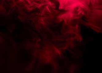 Abstract background of chaotically mixing puffs of red smoke on a dark background