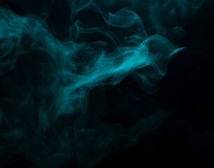 Abstract background of chaotically mixing clouds of turquoise smoke on a background of darkness
