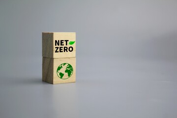 wooden cube with earth icon and word NET ZERO. The natural environment is a carbon neutral and net...