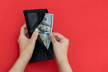 Woman hand holding a leather wallet with dollar - obrazy, fototapety, plakaty