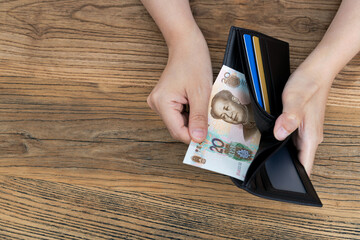 Woman hand holding a leather wallet with Chinese Renminbi