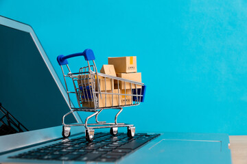 Shopping cart with boxes on laptop keyboard
