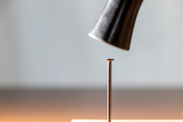 金づちで鉄釘を打つ