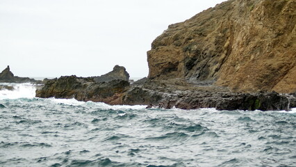 Fototapeta na wymiar Waves breaking on the rocky coast of Isla de la Plata, in the Machalilla National Park, off the coast of Puerto Lopez, Ecuador
