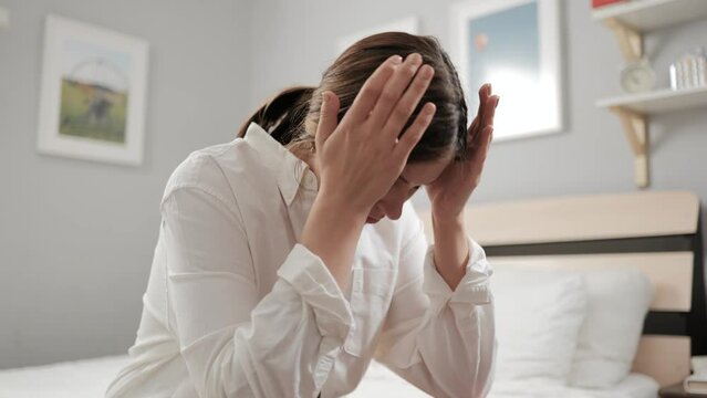 Headache, migraine. Hangover in bedroom in morning. Sick woman suffering from headache