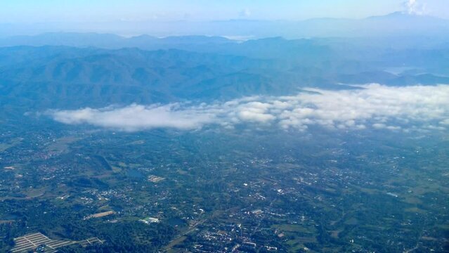 Airplane flies over City. Window view land as seen from the aircraft window. Aircraft flies through the clouds