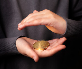 gold coin in human hands close up