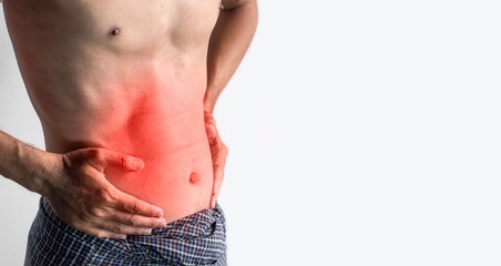 Asian young man suffering from abdominal pain. It can be caused by stomach ache, enteritis,...