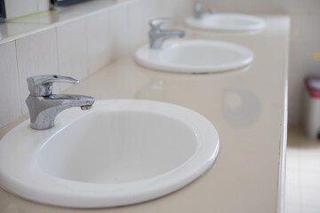 white sink faucet in public bathroom