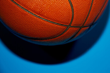 Basketball on a blue background at the top of the frame casts a shadow close-up..