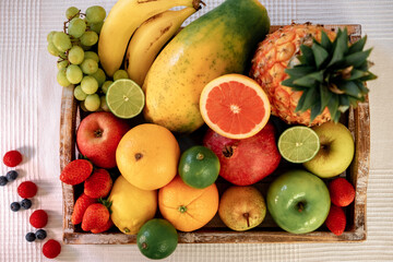 Close-up on a wooden basket full of colorful fresh fruit.  Healthy nutrition and lifestyle concept.
