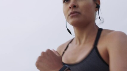 Fitness, woman and running on the beach for exercise, cardio workout or intense training in the nature outdoors. Active female runner listening to music while having a sports run on the ocean coast