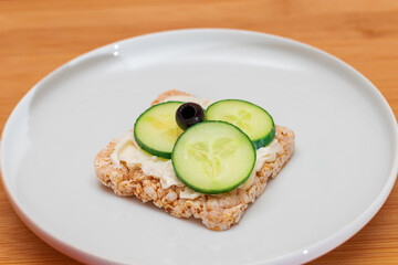Rice Cake Sandwich with Fresh Cucumber, Cream Cheese and Olives on White Plate. Easy Breakfast. Diet Food. Quick and Healthy Sandwiches. Crispbread with Tasty Filling. Healthy Dietary Snack