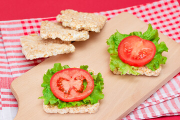 Rice Cake Sandwiches with Tomato and Lettuce on Wooden Cutting Board. Easy Breakfast. Diet Food. Quick and Healthy Sandwiches. Crispbread with Tasty Filling. Healthy Dietary Snack