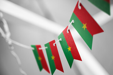 A garland of Burkina Faso national flags on an abstract blurred background