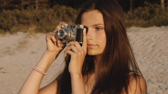 Medium Close-up Shot Of A Teen Focusing Her Camera Towards The Sea