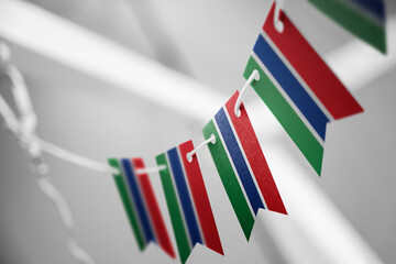 Obraz premium A garland of Gambia national flags on an abstract blurred background