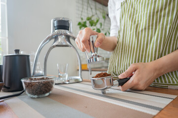 Barista prepares espresso in her coffee shop close-up