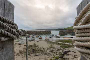 The boats in the harbor tied to the peer under the cloudy sky on a gloomy day