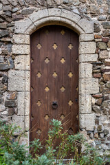 Fototapeta na wymiar A vertical shot of an old wooden arched door of the medieval building