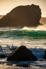 Majestic landscape image of jade turquoise waves crashing onto shore and rocks in Kynance Cove...