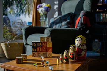 A  1970's retro lounge, toys placed on a table. Lettered bricks spell play time. A set of Russian...
