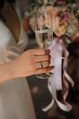 bride holding glass with a ing on her finger