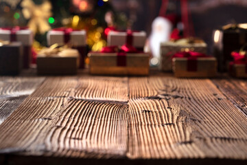 Christmas time. Christmas presents on rustic wooden table. Shallow depth of focus. Colorful bokeh lights.