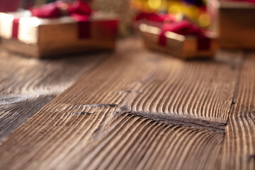 Christmas time. Christmas presents on rustic wooden table. Shallow depth of focus. Colorful bokeh lights.