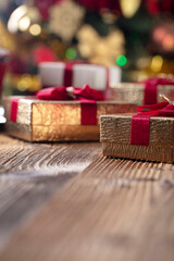 Naklejka na ściany i meble Christmas time. Christmas presents on rustic wooden table. Shallow depth of focus. Colorful bokeh lights.