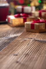 Christmas time. Christmas presents on rustic wooden table. Shallow depth of focus. Colorful bokeh lights.