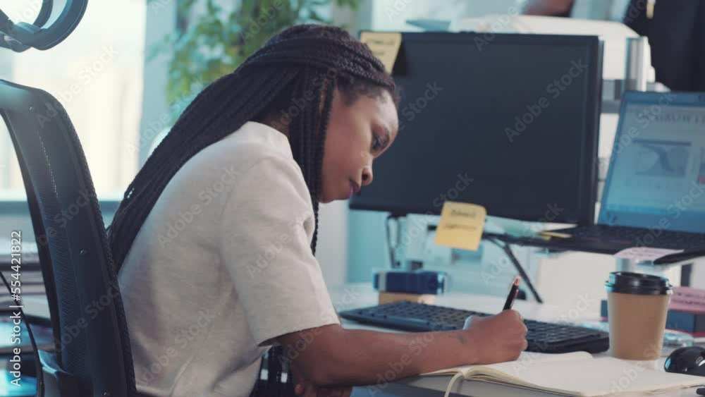 Poster writing, business woman and marketing employee working on a office schedule in a notebook. black wom