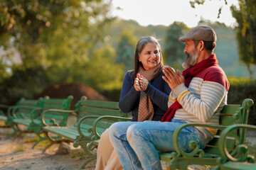 old couple in warm wear in winter at park