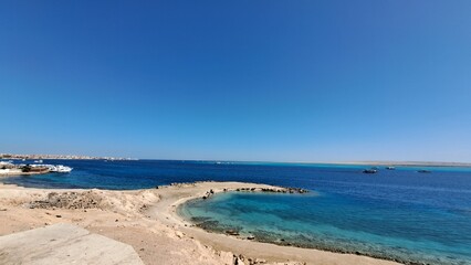 Fototapeta na wymiar Beach and sea. Blue sky and white clouds. Boats. Red sea. Egypt. Hurghada