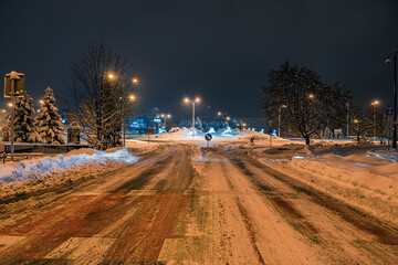 Mocno zasypane śniegiem droga i chodnik w mieście przemysłowym na Śląsku w Polsce, Jastrzębie-Zdrój nocą. - obrazy, fototapety, plakaty