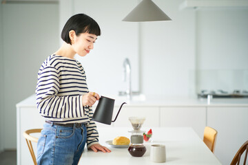 部屋でコーヒーを淹れる若い女性