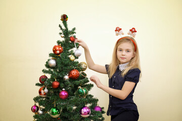 Happy girl decorating christmas tree.