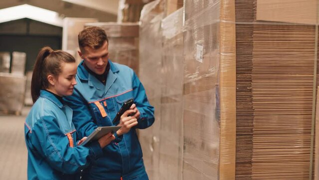 Managers scan a barcode at a packaging factory. Warehouse. QR code on pallets.