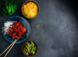 Asian traditional food rice noodles with sweet pepper, sweet and sour chicken and beans.