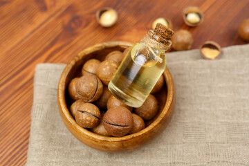 Close up view of natural macadamia oil and macadamia nuts. Selective focus