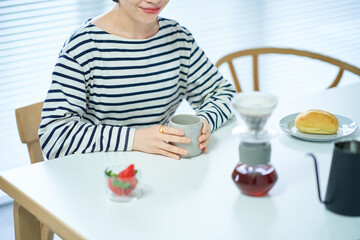 部屋でコーヒーを飲む若い女性