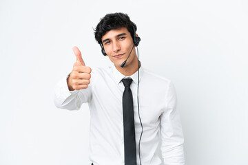 Telemarketer man working with a headset isolated on white background with thumbs up because something good has happened