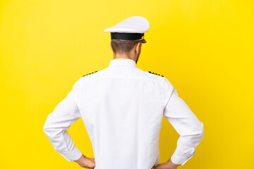Airplane caucasian pilot isolated on yellow background in back position