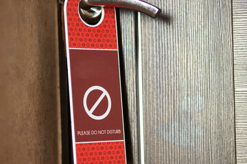 do not disturb sign on the closed door of the hotel room
