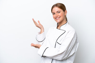 Young chef woman isolated on white background extending hands to the side for inviting to come
