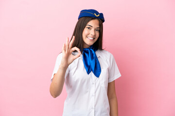 Airplane stewardess Brazilian woman isolated on pink background showing ok sign with fingers