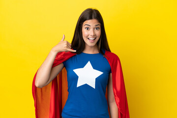 Super Hero Brazilian woman isolated on yellow background making phone gesture. Call me back sign